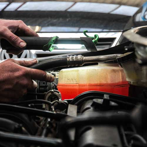 Mechanic checking the level of coolant in a car